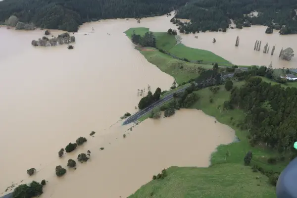 Brown floodwaters engulf a road